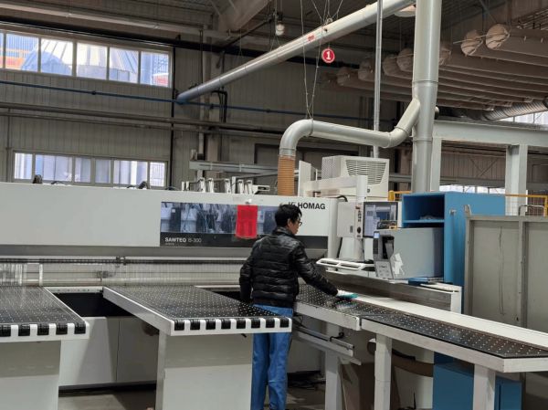 飞美家具智能制造生产线上，工人在对着电脑操作程序